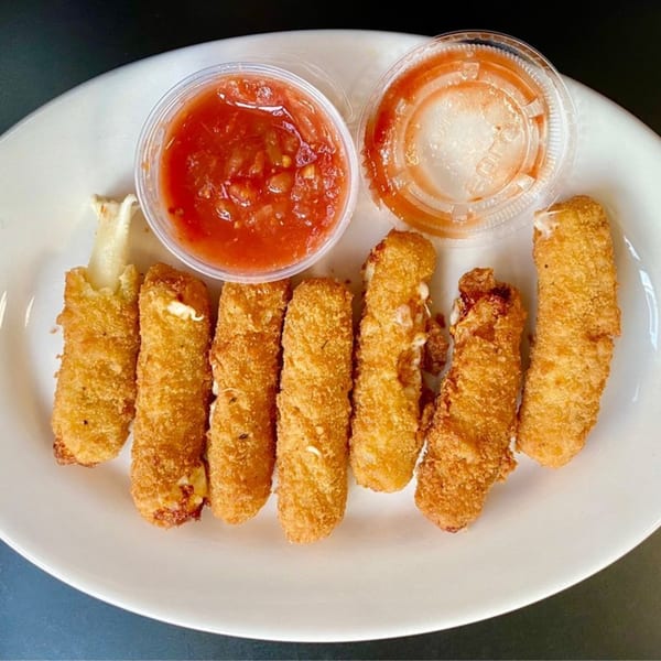 Golden-brown mozzarella sticks with melted cheese and two cups of salsa on a white plate.